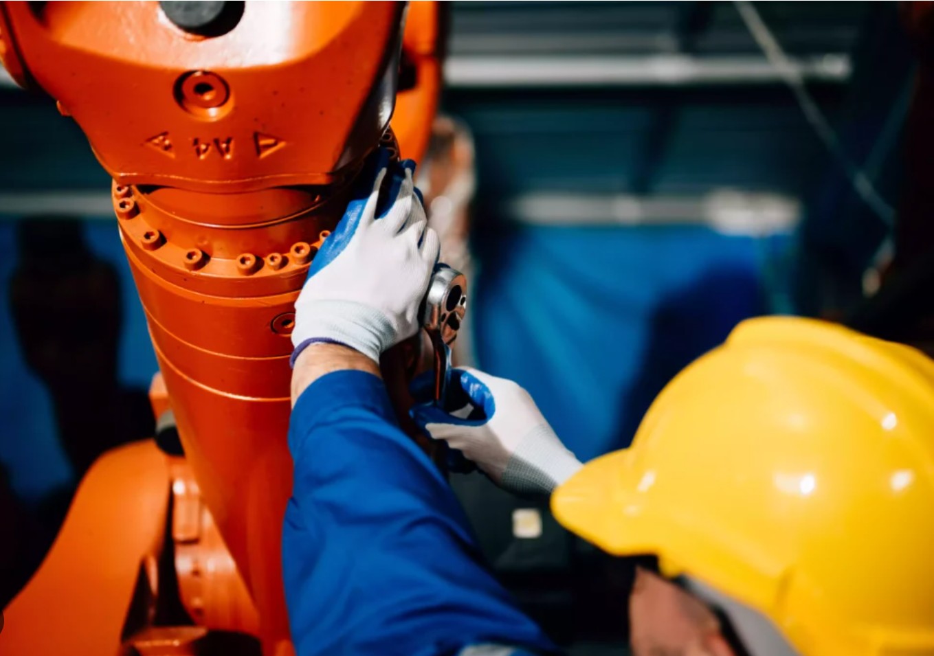 Worker performing maintenance on industrial robot